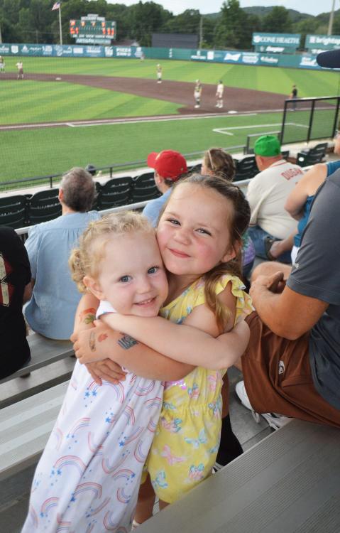 Two children sharing a hug during an Asheboro ZooKeepers game at McCrary Park in Asheboro, NC