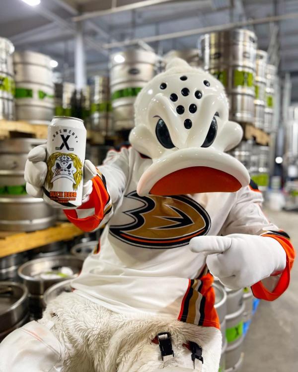 Image of Wild Wing, the Anaheim Ducks mascot, sitting down with a beer can from Brewery X that has Wild Wing's face on the can.