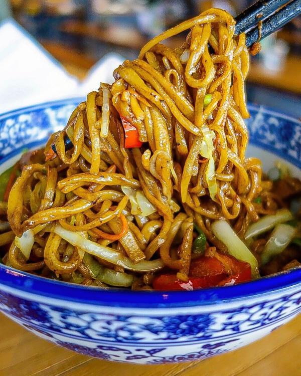 Close up view of chow mien noodles and stir fried vegetables 