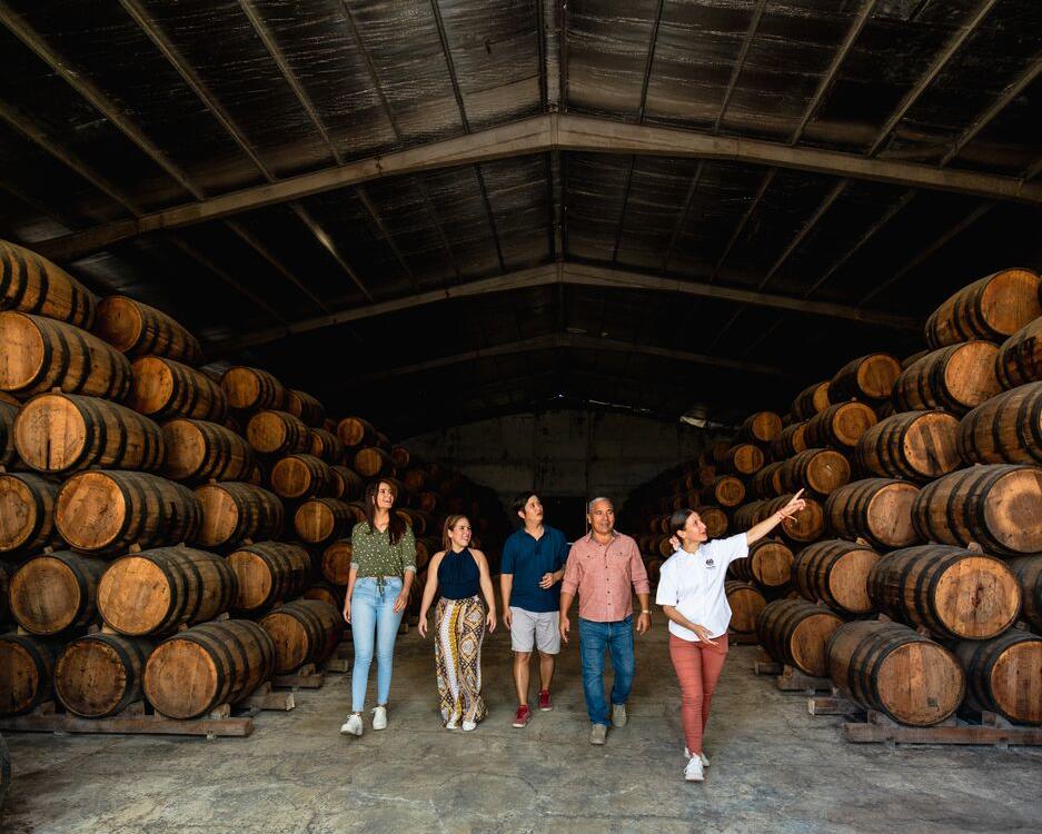 Explorers examining the contents of rum barrels in a storage area of Hacienda San Isidro, Herrera province