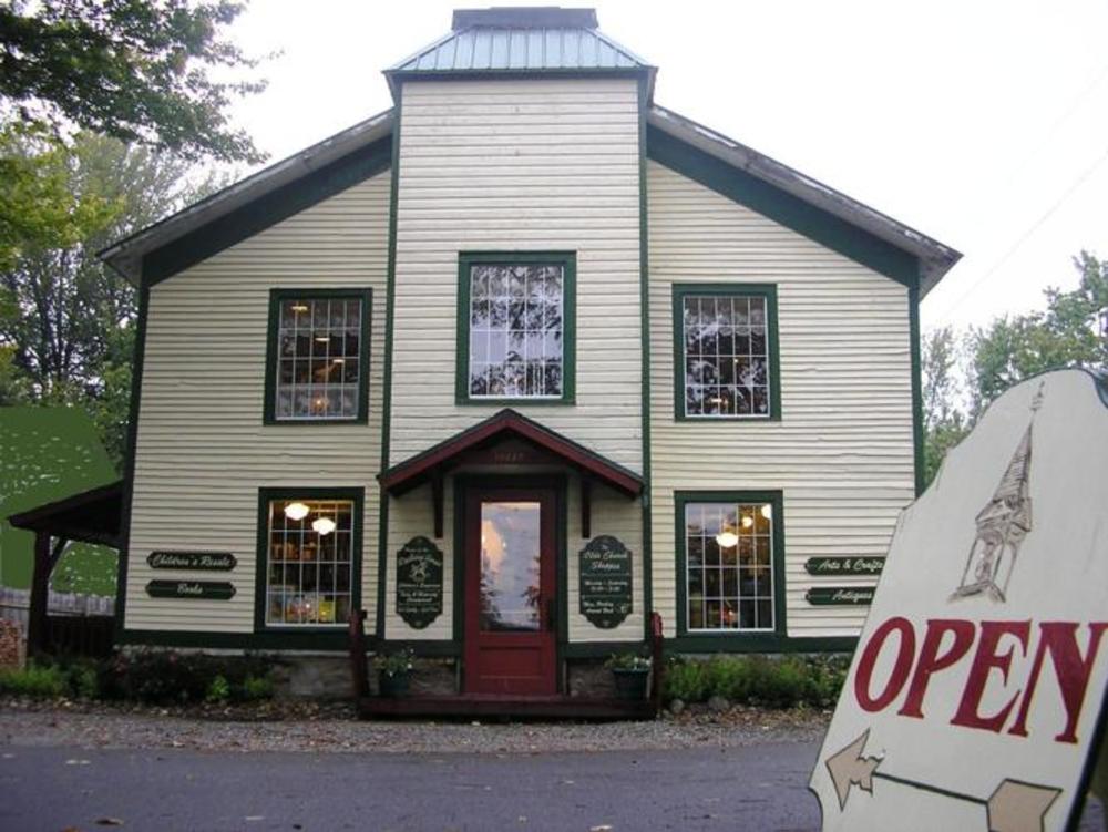The exterior of an old white and green church building refurbished into a boutique store.