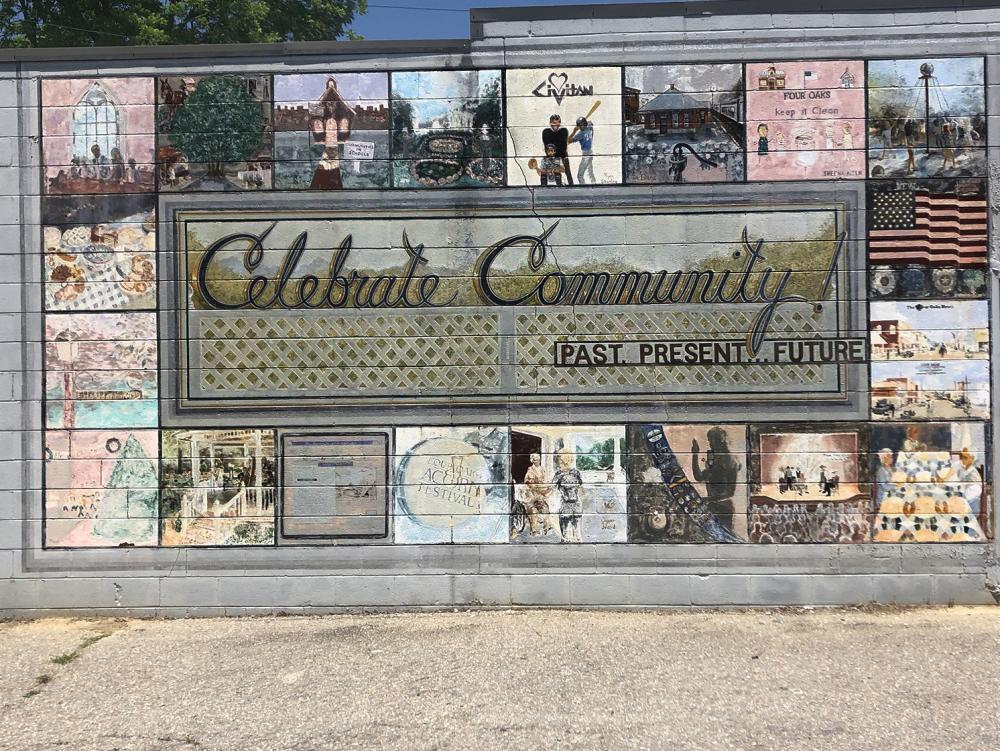 Mural with historic depictions and Celebrate Community in the center in Four Oaks
