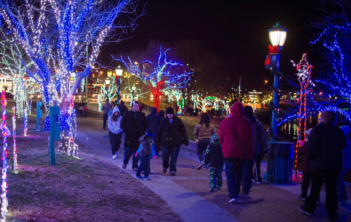 people walking through Christmas light displays