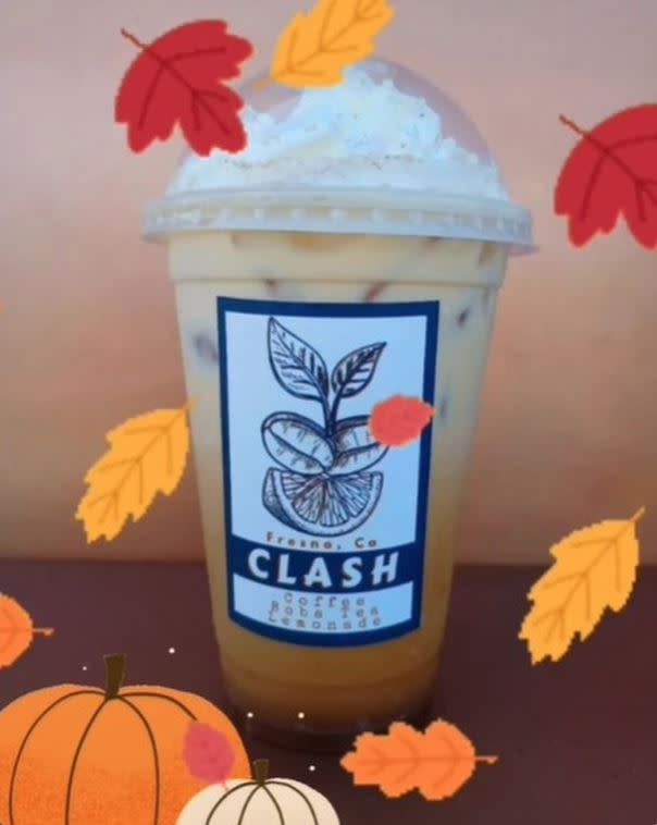 Cup of pumpkin spice latte with whipped cream and leaves and pumpkin stickers