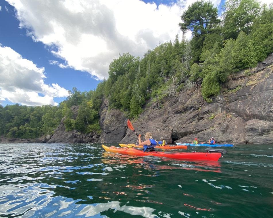 Group tour kayaking along the rugged rock formations on Lake Superior