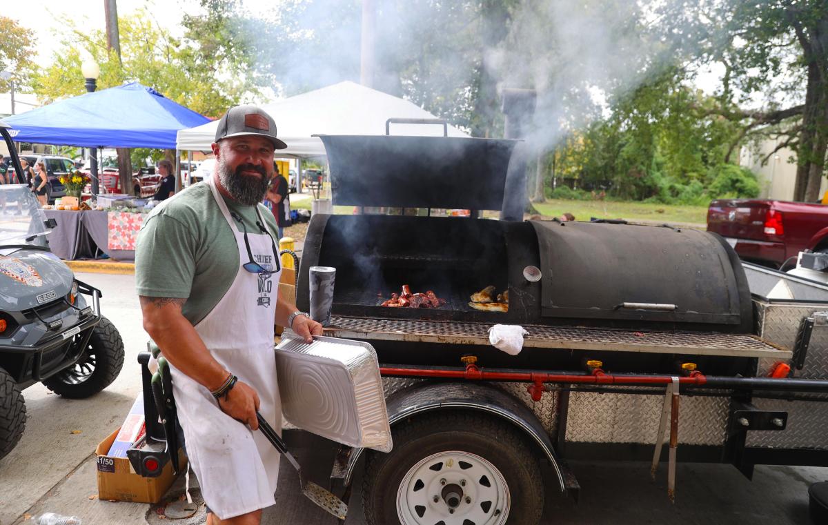 A cook stands beside a smoking barbecue pit loaded with meat during the Wild Game, Seafood & BBQ Cook-off in Slidell.