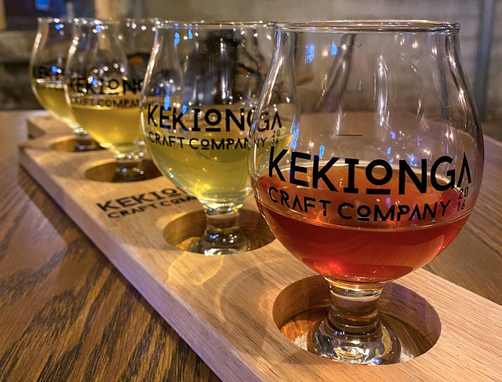 Four drinking glasses with different colored hard cider