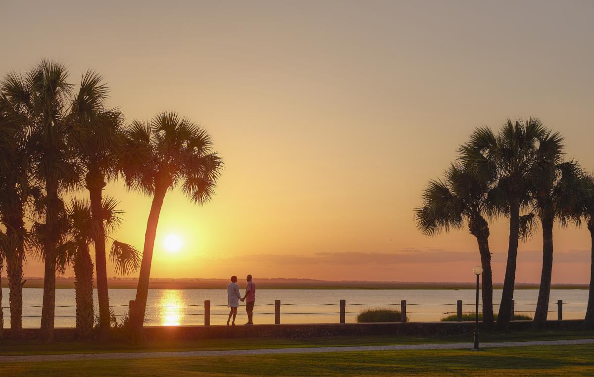 A couple enjoys the sunset along the Jekyll River in the Jekyll Island Historic District