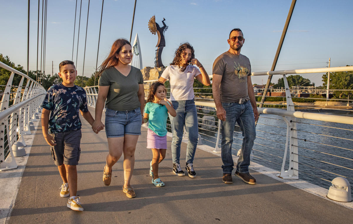 A family walks across the bridge at the Keeper of the Plains