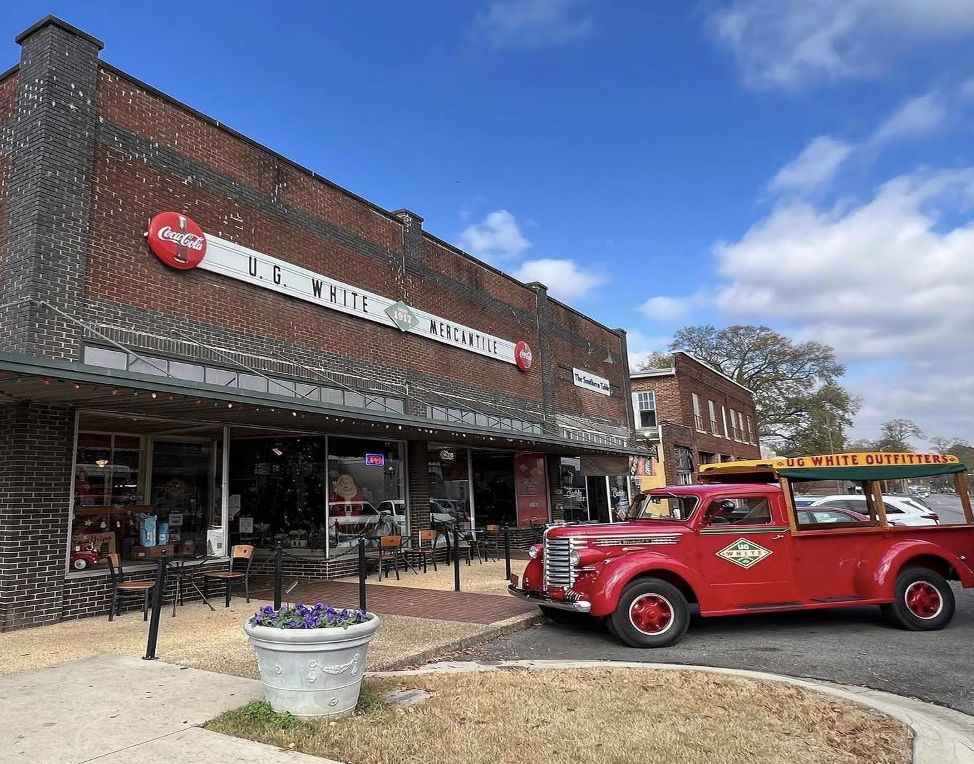 front of the UG White storefront in downtown Athens with an old timey truck parked out front