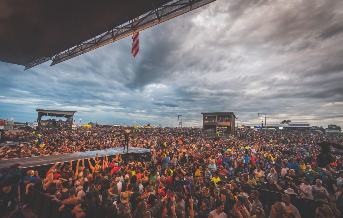 Country music artist standing on stage surrounded by a crowd at Country Fest