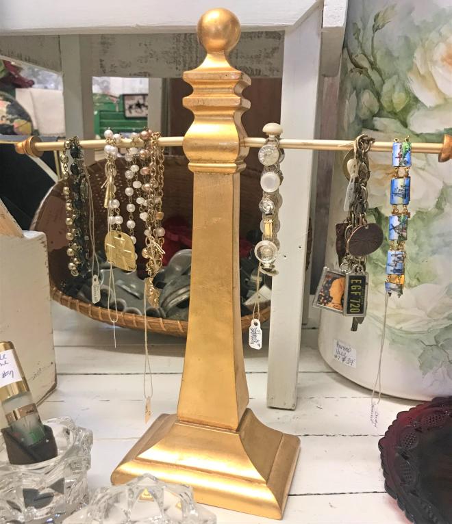 antique necklaces on golden necklace hanger in vintage shop