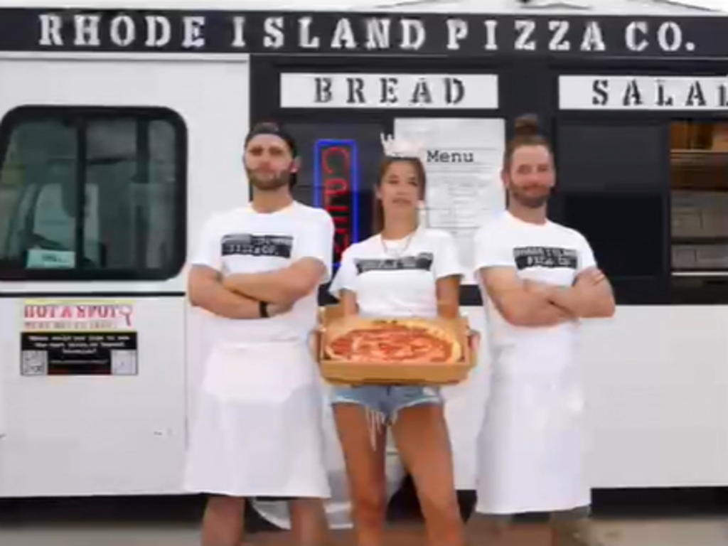 Staff holding pizza.