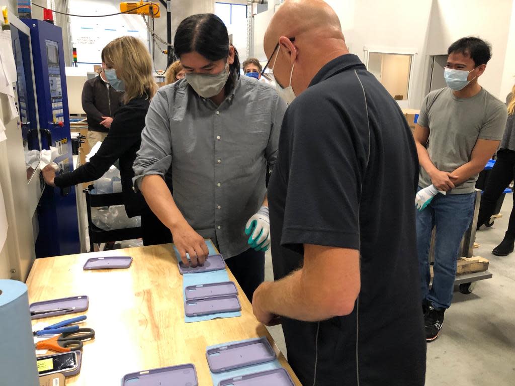 A group getting a tour of Pela and looking at phone cases