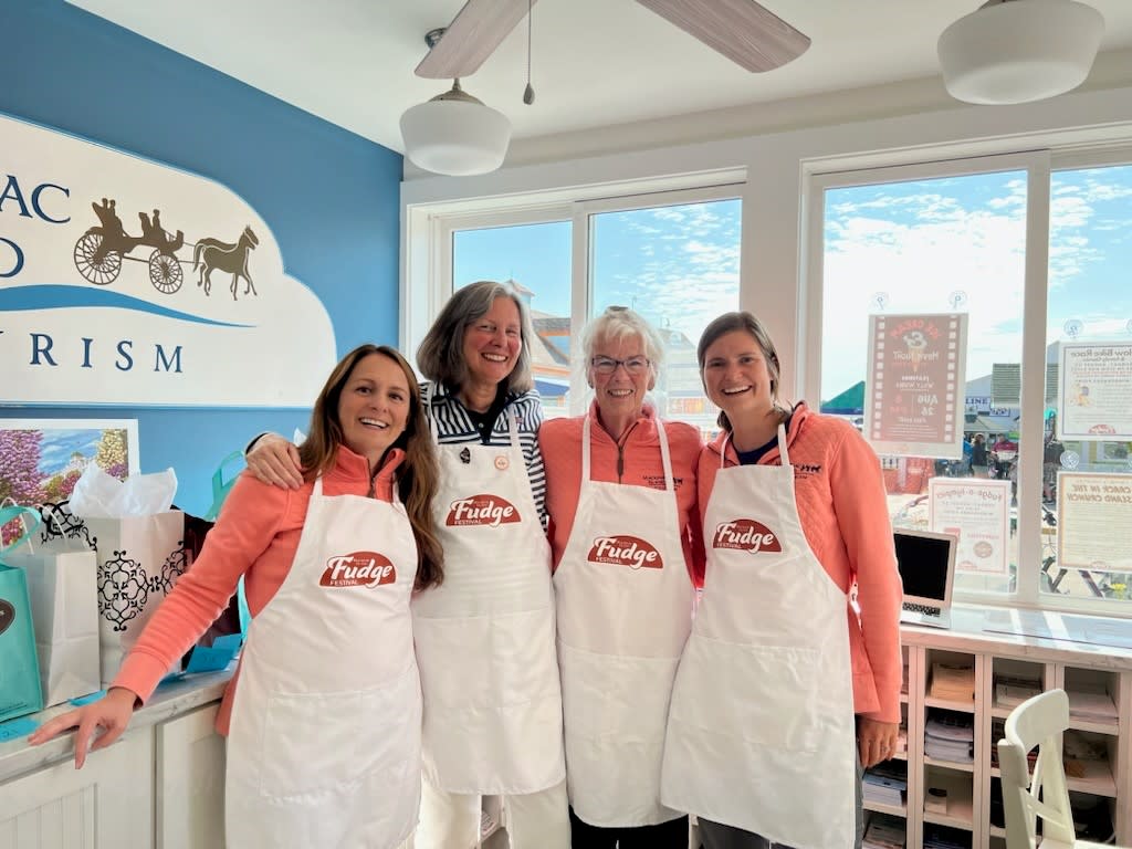 Mackinac Island Tourism Bureau information specialists wearing Fudge Festival aprons