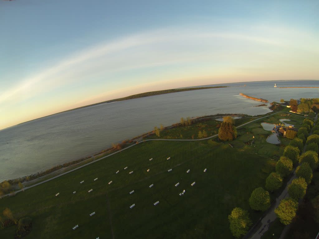 An aerial drone photo shows the great lawn dotted with Adirondack chairs on the waterfront at Mackinac Island’s Mission Point Resort
