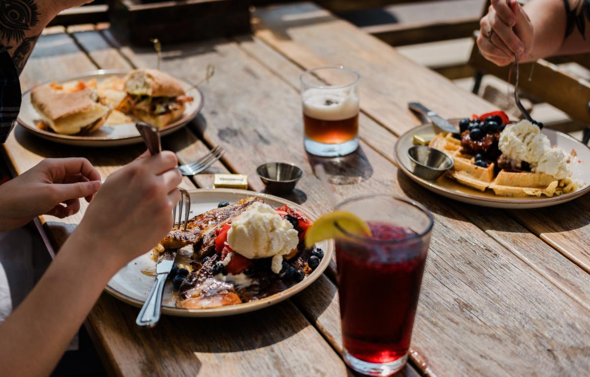 A table of delicious food on the outdoor patio at Root Cellar Cafe in Downtown San Marcos, Texas
