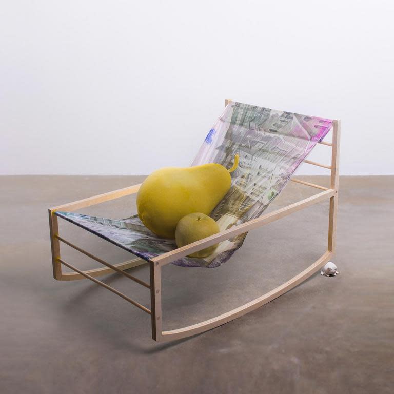 Image of a canvas and metal chair with a pear and kiwi sitting on it together.