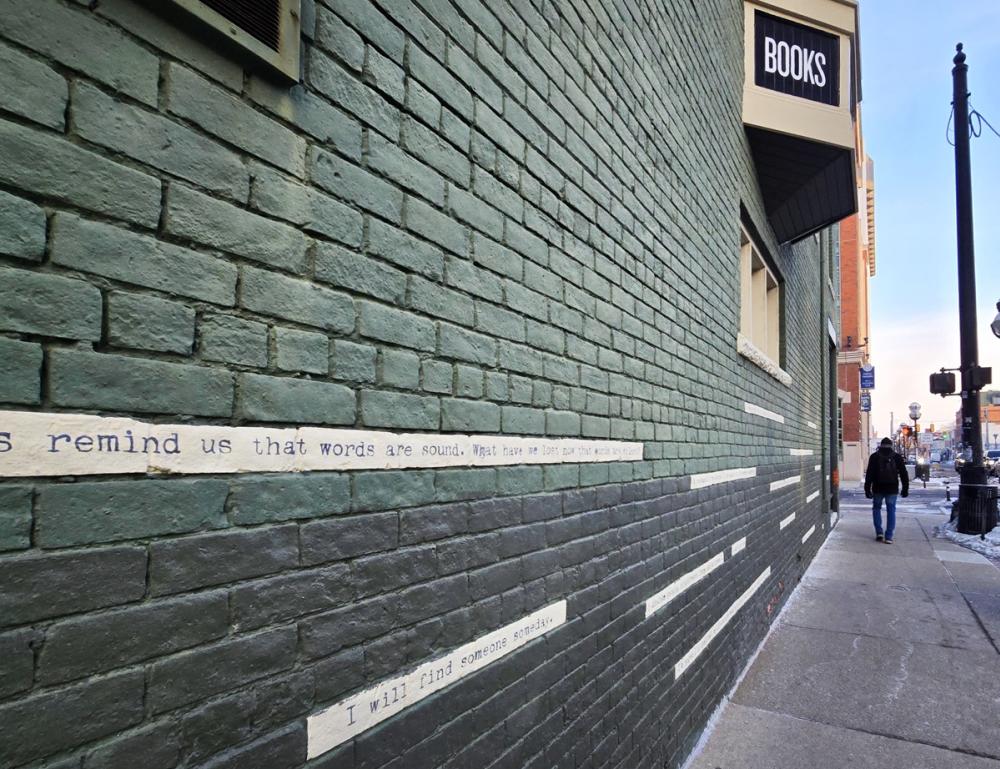 Exterior view of Literati Bookstore, with bricks several etched with poetic lines.