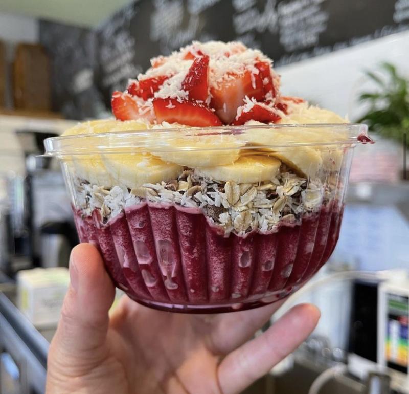 acai bowl with bananas, strawberries, and coconut shreds on top