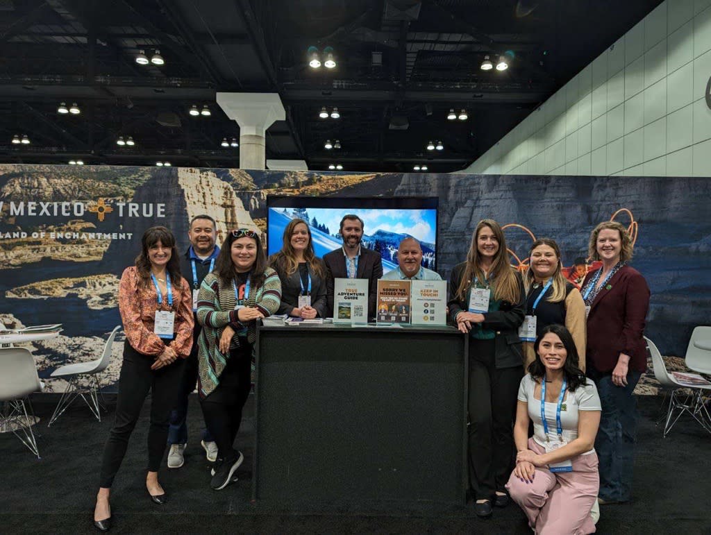 The New Mexico True and Visit Albuquerque teams pose in front of their IPW booths