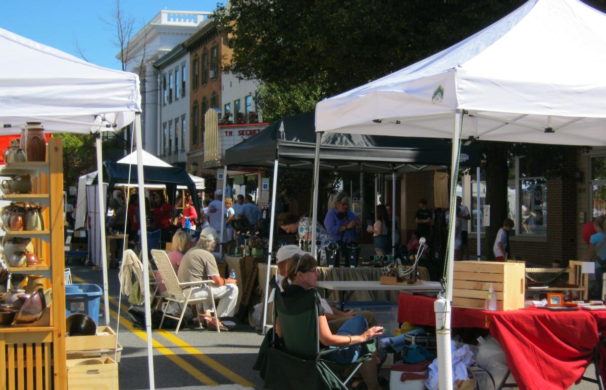 Vendors sitting at their tents at the Harvest of the Arts