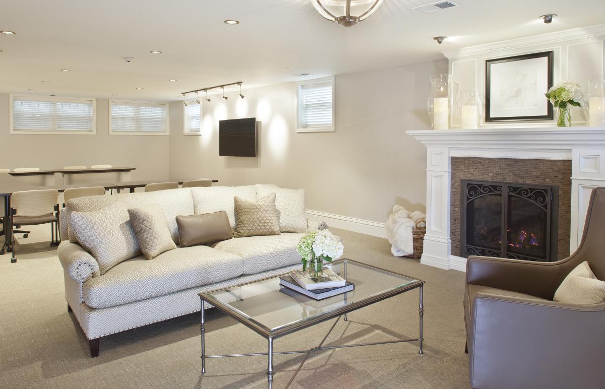 Photo of conference room at Edwards House with Couch, chair, fireplace and table with TV for presentations.