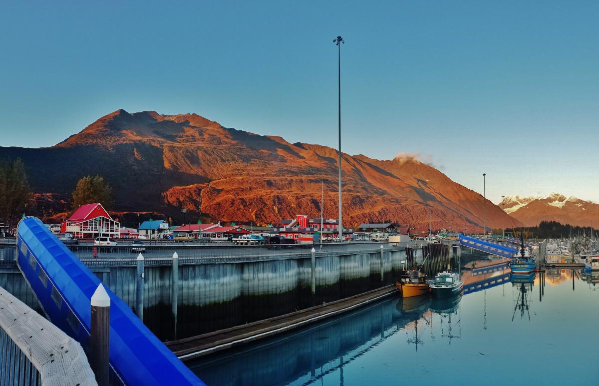 a harbor and a business district in Valdez. Mountains in background