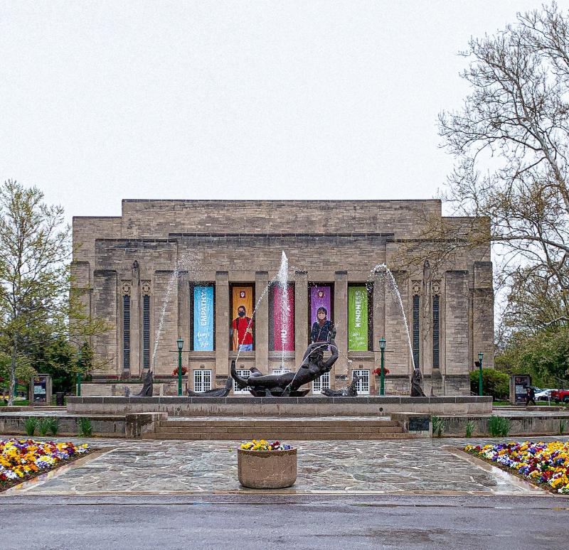 Showalter Fountain surrounded by budding foliage on a rainy spring day