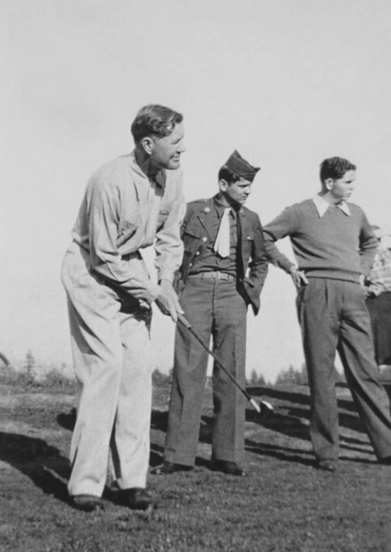 Man golfing with two friends
