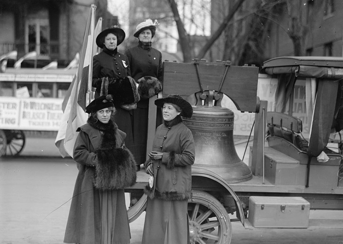 A 1916 photograph by Harris & Ewing of women in fur-adorned coats and mink muffs gathered around the Justice Bell, a replica of the Liberty Bell, to campaign for women's suffrage.