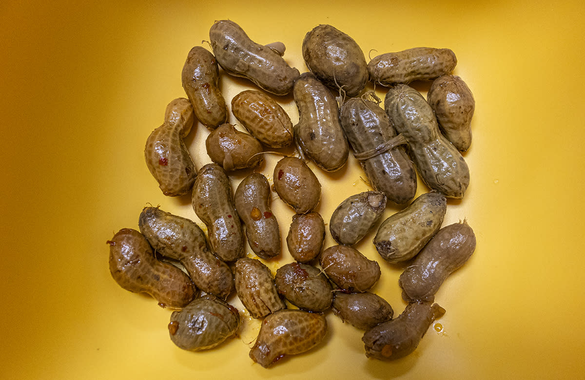 Boiled peanuts sit in a yellow bowl.