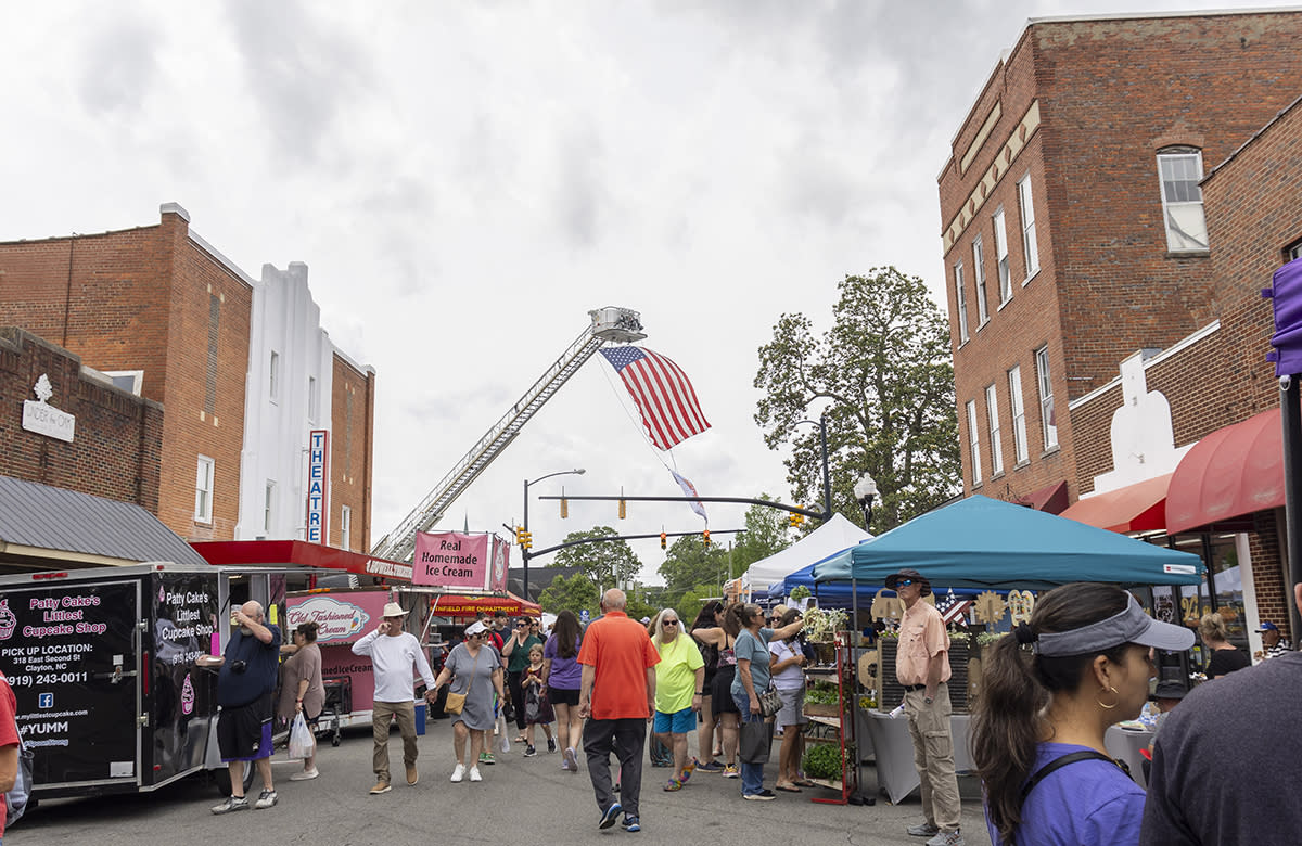 A crowd of people walk through a variety of vendors during the Smithfield Ham & Yam Festival.