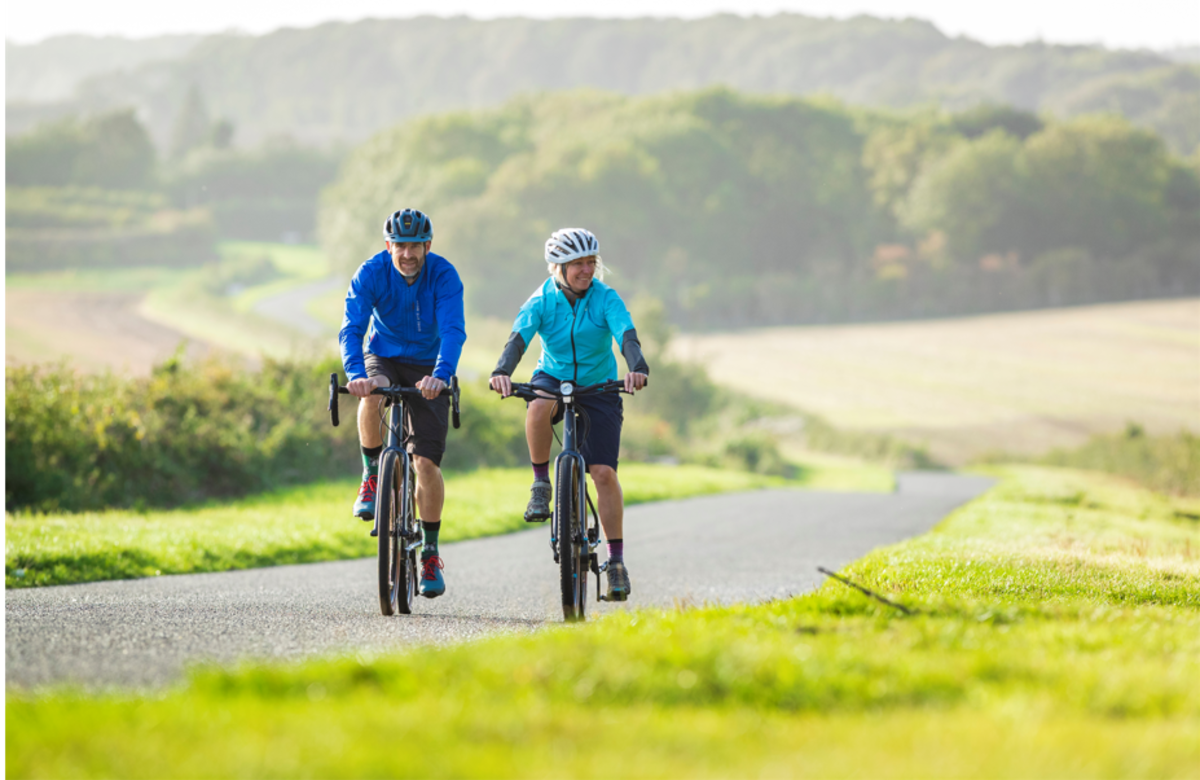 A couple cycling through North Lincolnshire, with the undulating countryside in the background