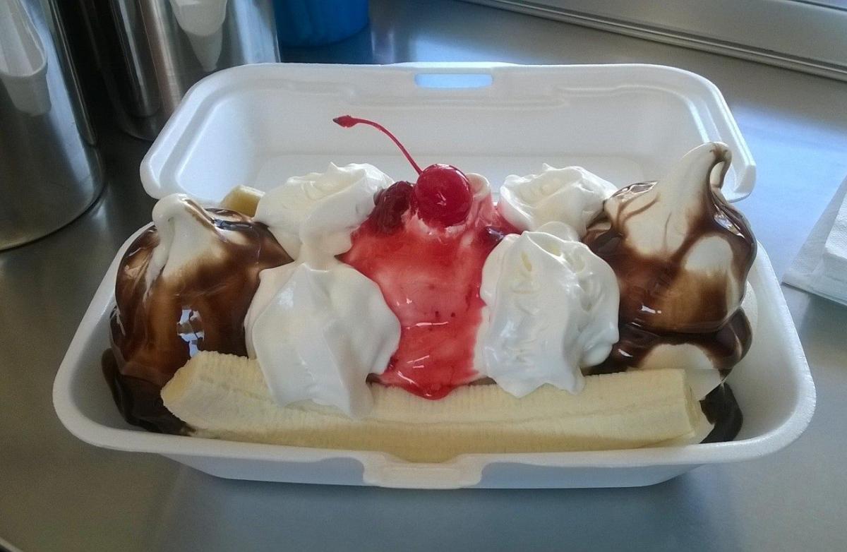 A to-go container with a banana split on display.