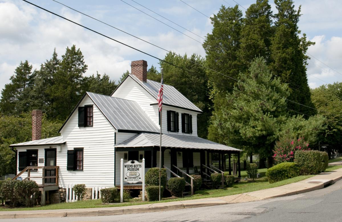 A historic white building with trees behind it
