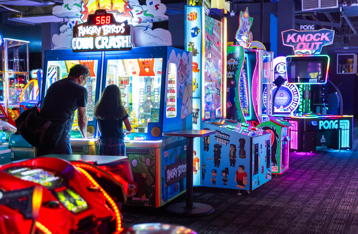 Father and daughter playing an arcade game.