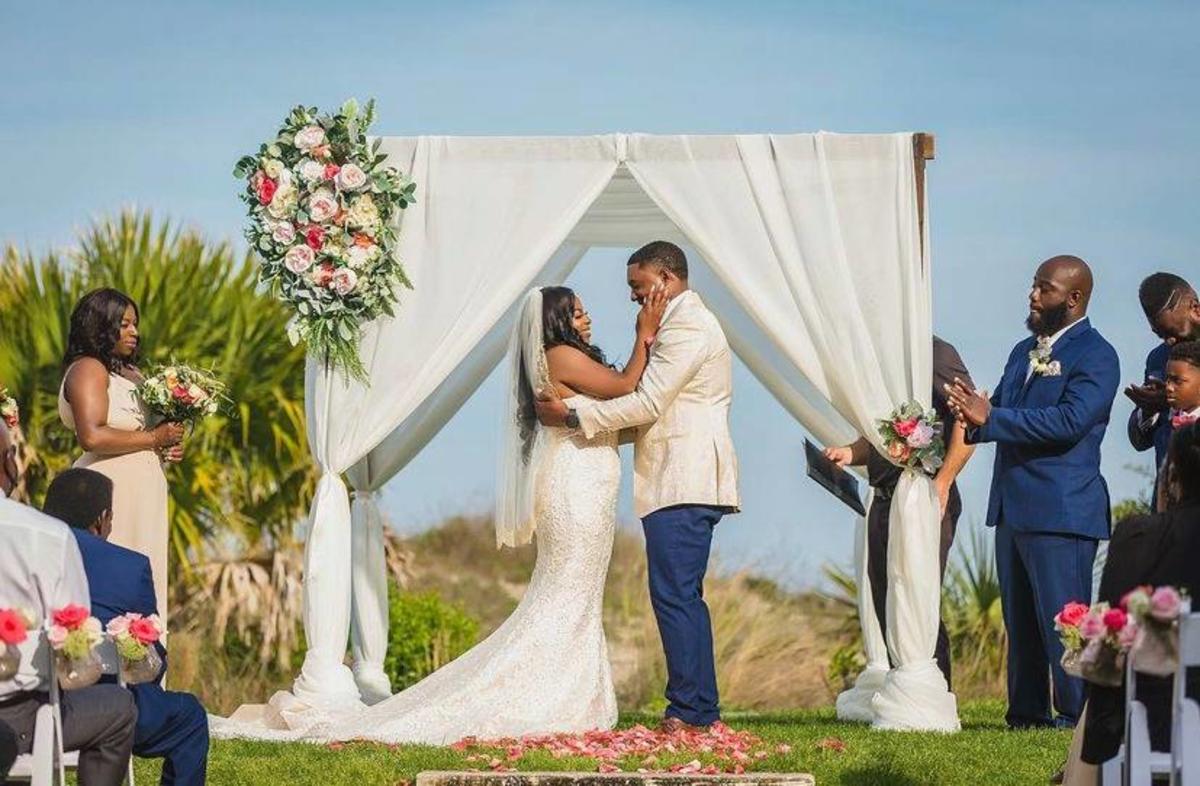 A couple getting married under a canopy outside