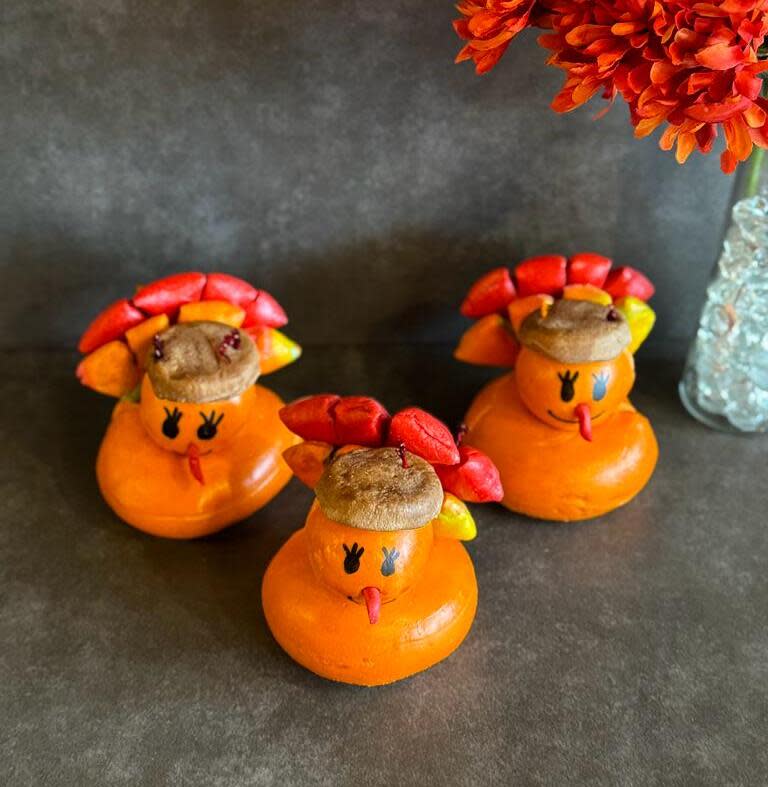 Three turkey shaped bagels in colorful reds, oranges, and yellows