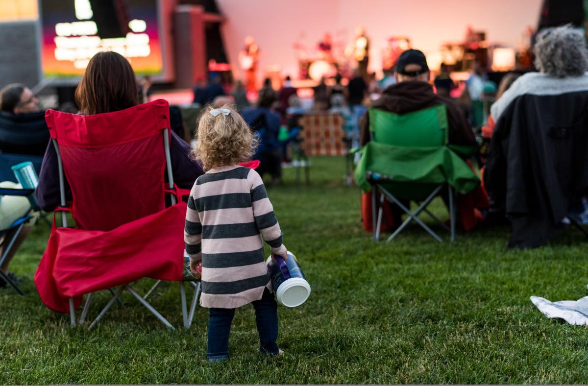 A little girl listens to a concert at Levitt Pavilion