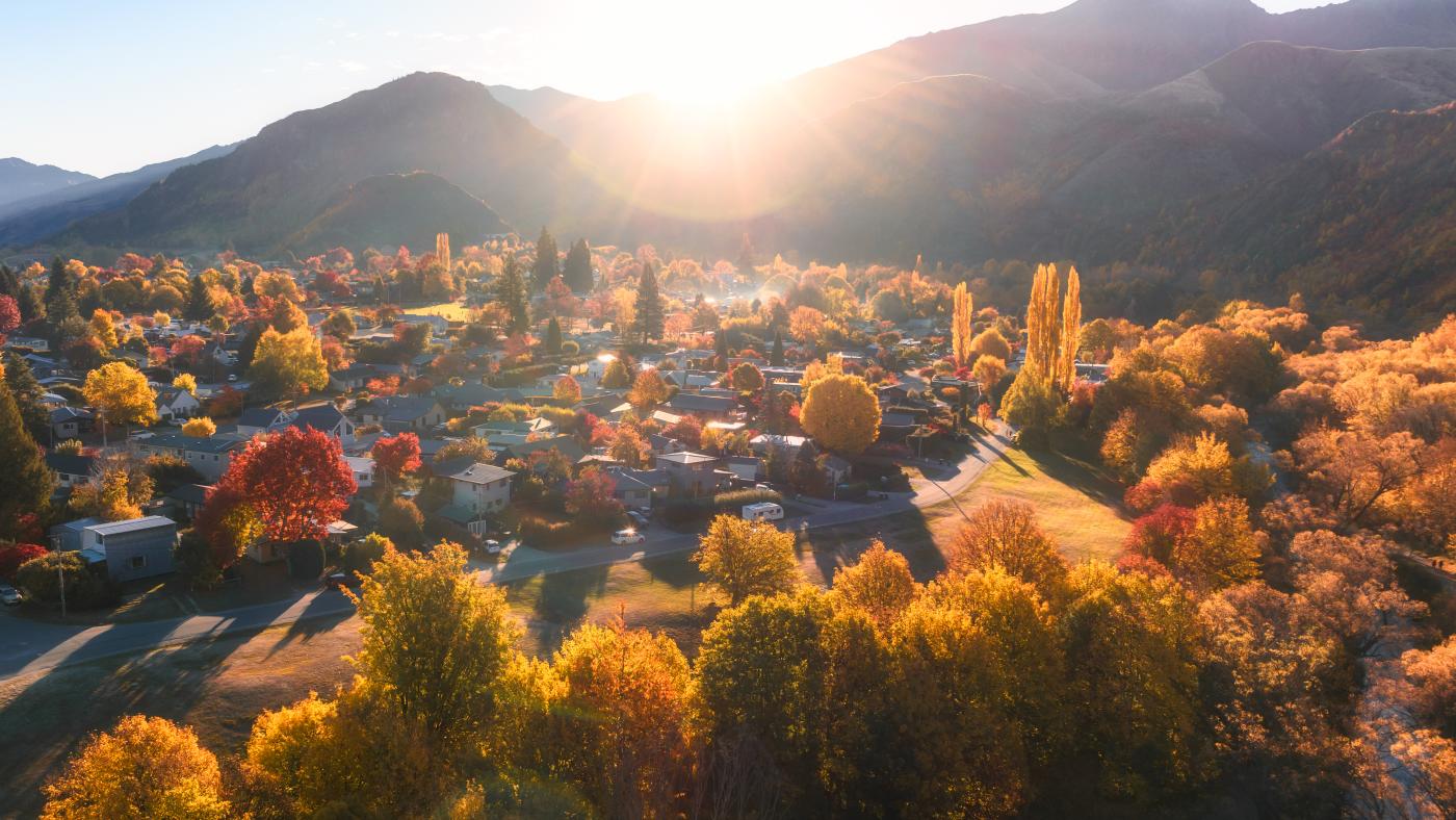 Aerial photo of Arrowtown full of gold and red trees in Autumn