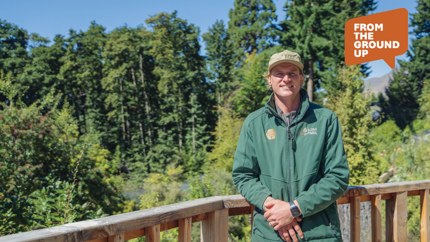 Man standing looking at the camera with trees in the background