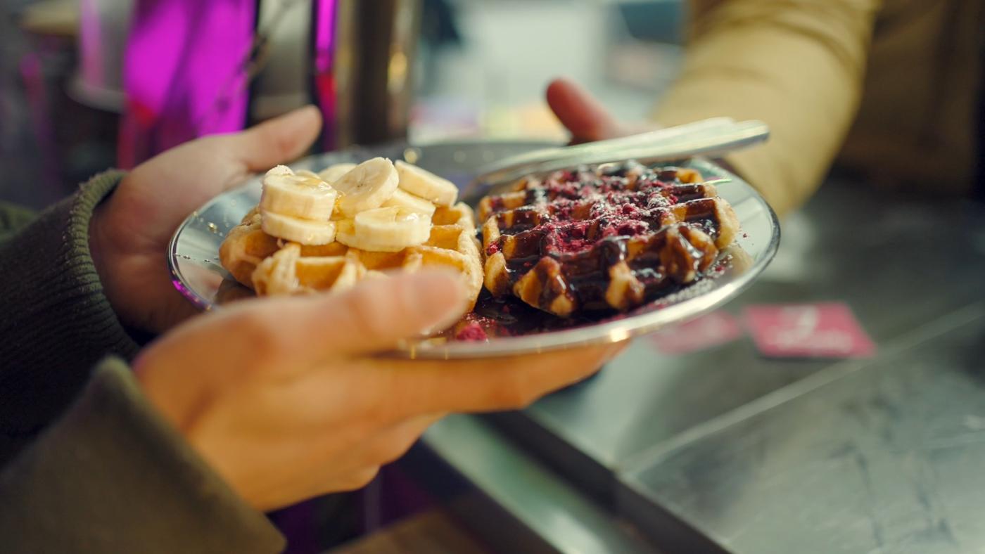 Person holding a plate with waffles
