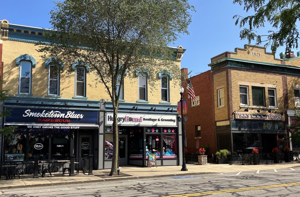 Historic buildings with modern storefronts line a downtown street.