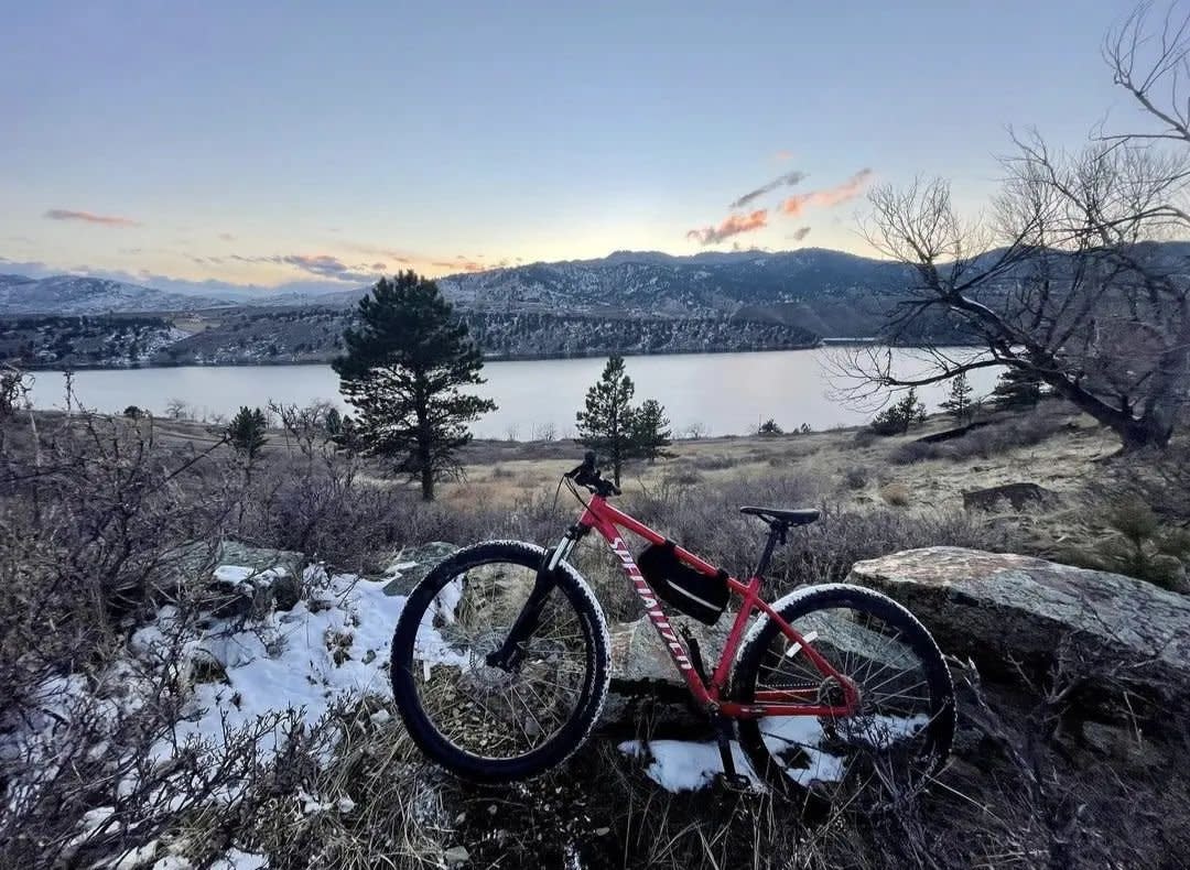 Bike leaning against a rock with snow in the ground