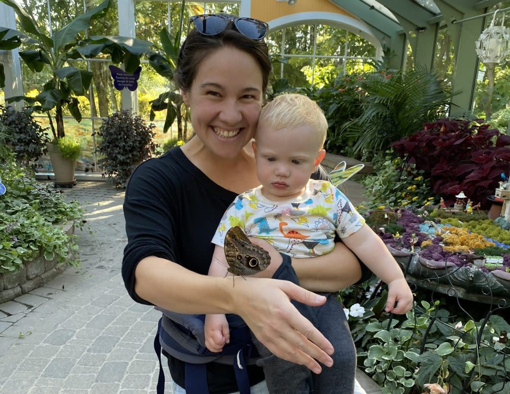 A woman and child enjoy an up-close encounter with a butterfly at the Wings of Mackinac conservatory on Mackinac Island.