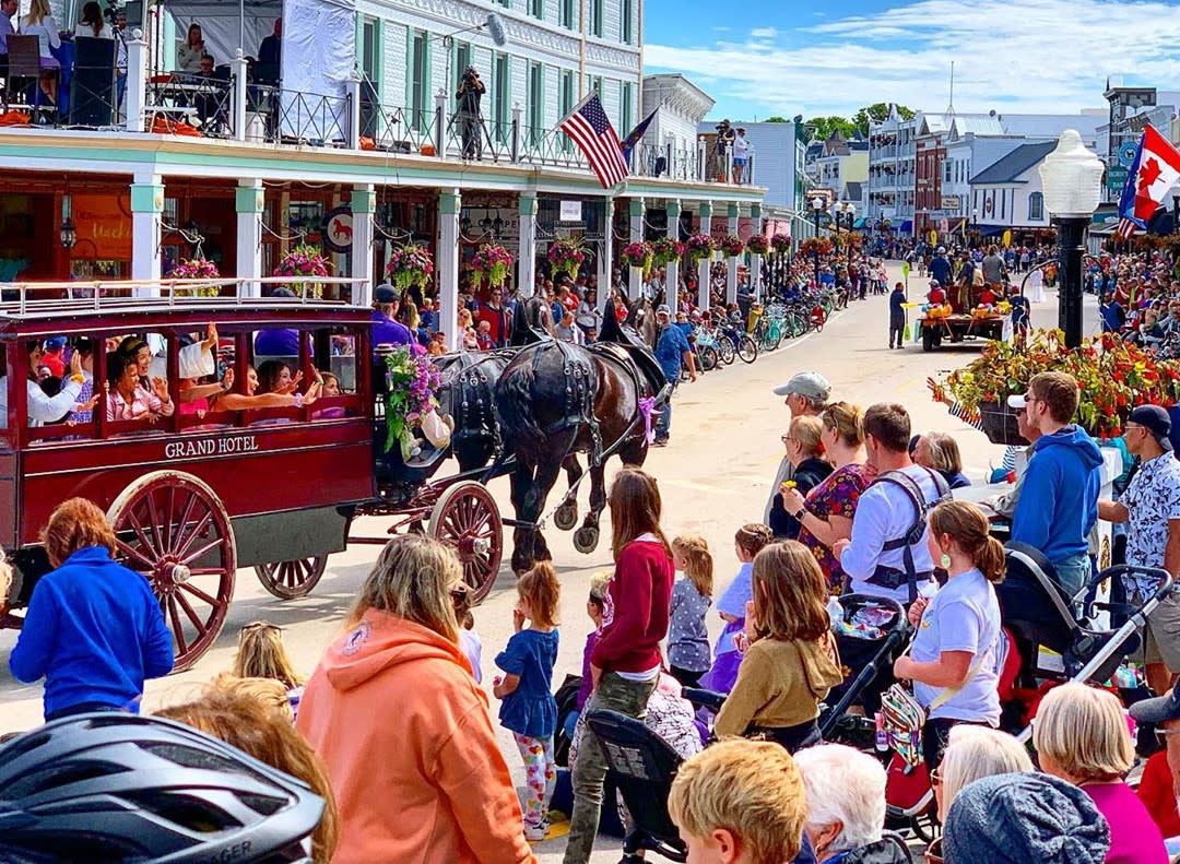 A horse-drawn carriage makes its way through the crowd during the annual Mackinac Island Lilac Festival Grand Parade