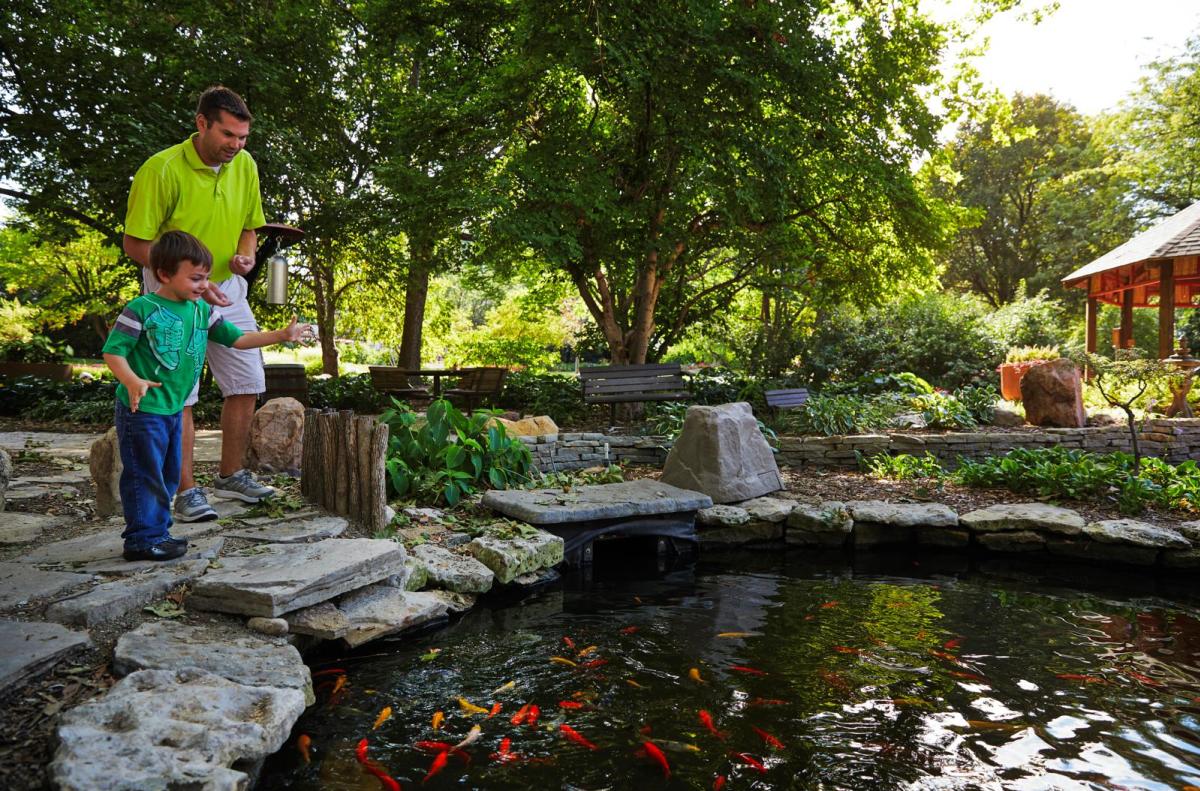 Family feeds fish at Ward Meade Botanical Garden in Topeka