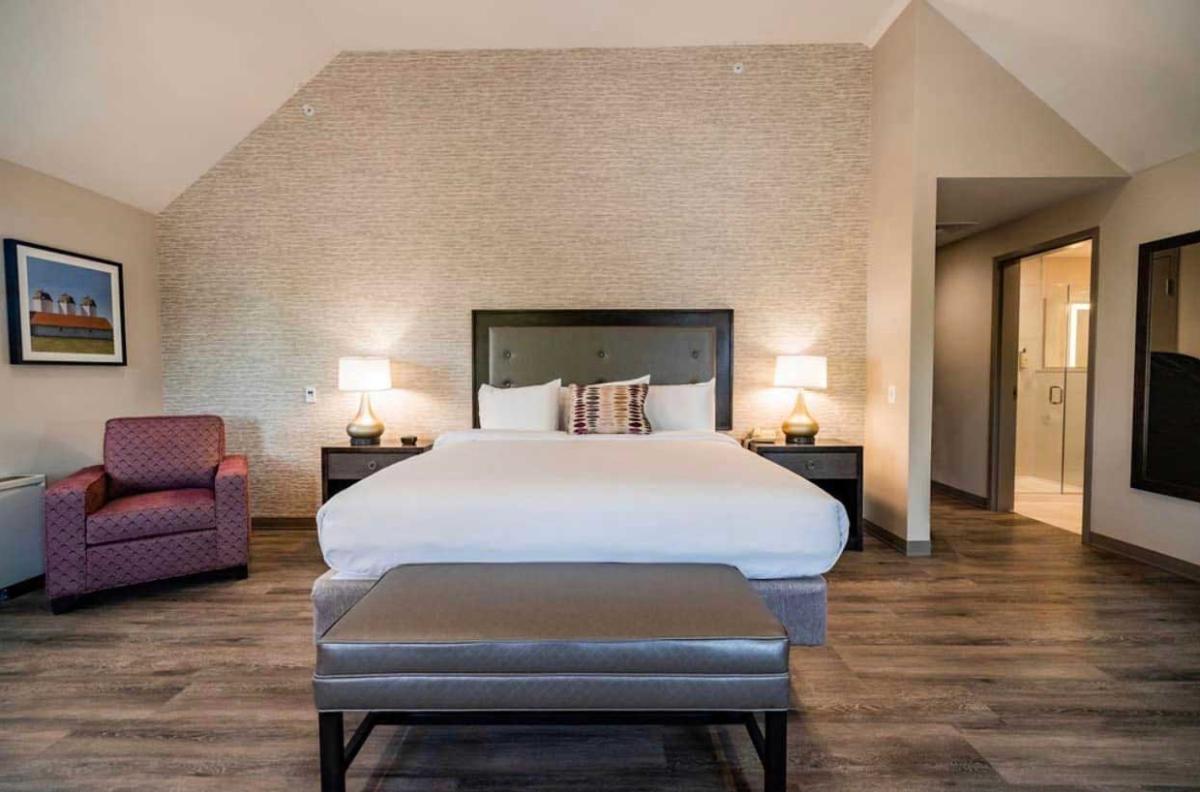 A bedroom with a bed and chairs