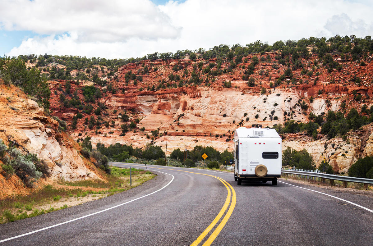 The view of the back of an RV driving through the red rocks of southern Utah